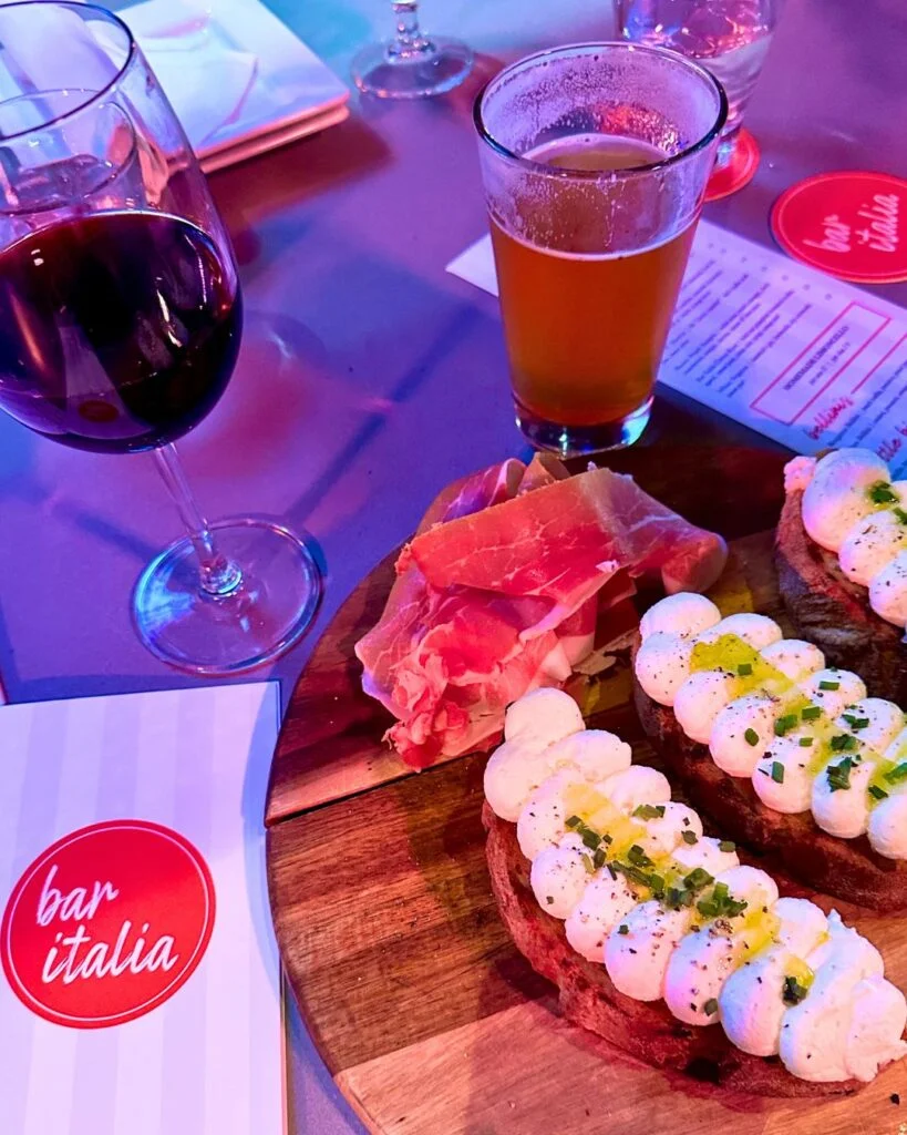 Image of glass of wine, a beer, and food at Bar Italian Happy Hour