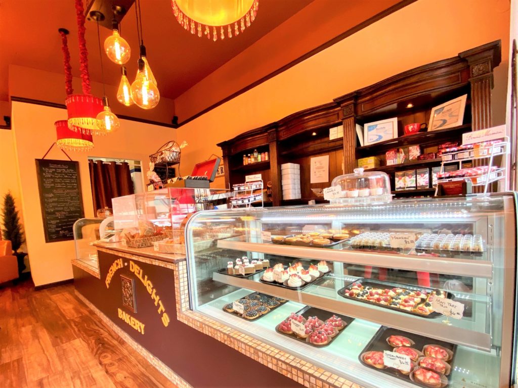Dining area and pastry display case at French Delights Bakery Cocoa Village 