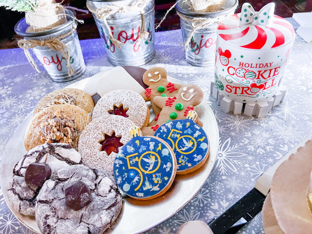 EPCOT Holiday Cookie Stroll is showcased on a white platter with a red and white peppermint style cookie jar to the right of the platter