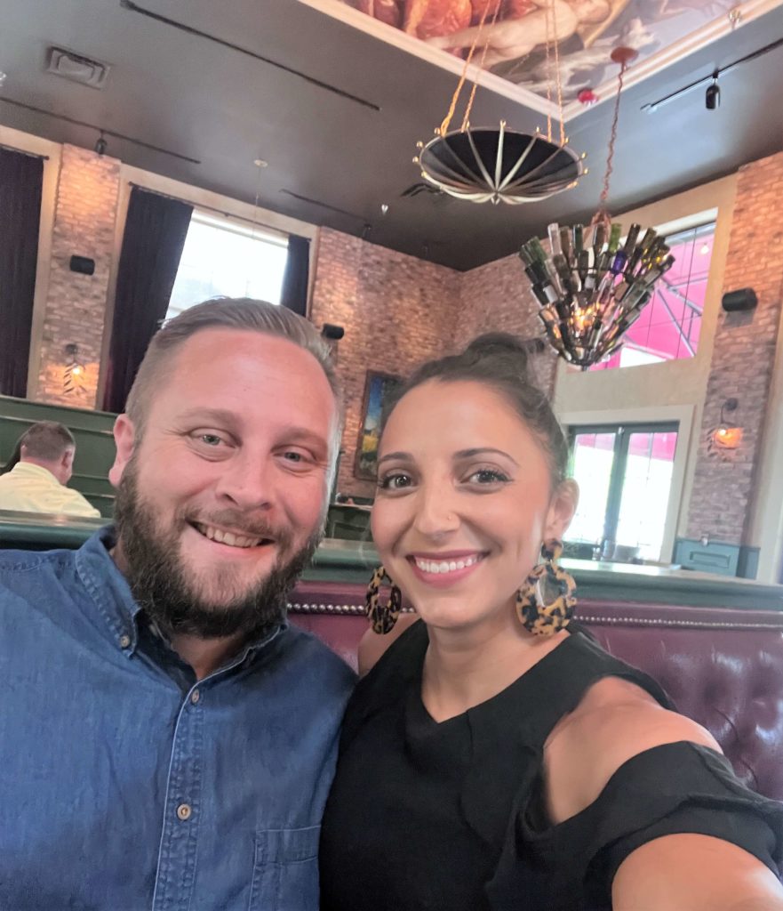 A selfie style photo of a couple dressed up at dinner for a date night