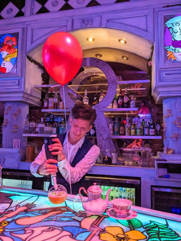 a bartender serves up creative Cocktails at High T Alice in Wonderland Bar Downtown Orlando