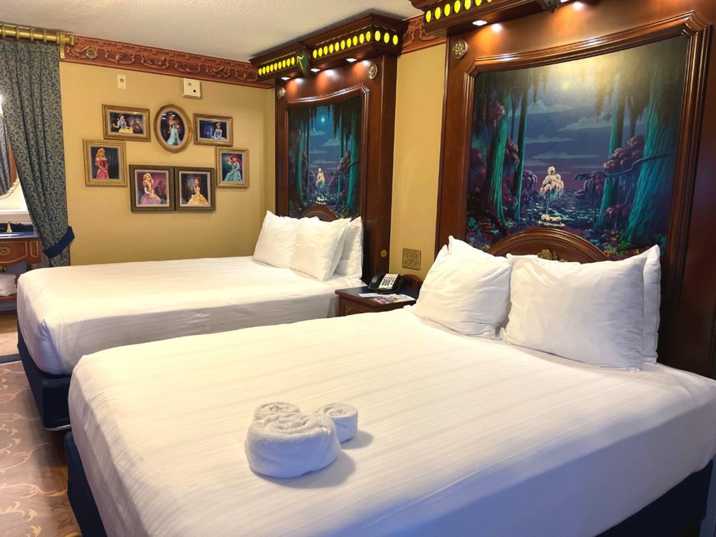 looking at two beds with princess themed details inside Disney's Port Orleans Royal Guest Room 