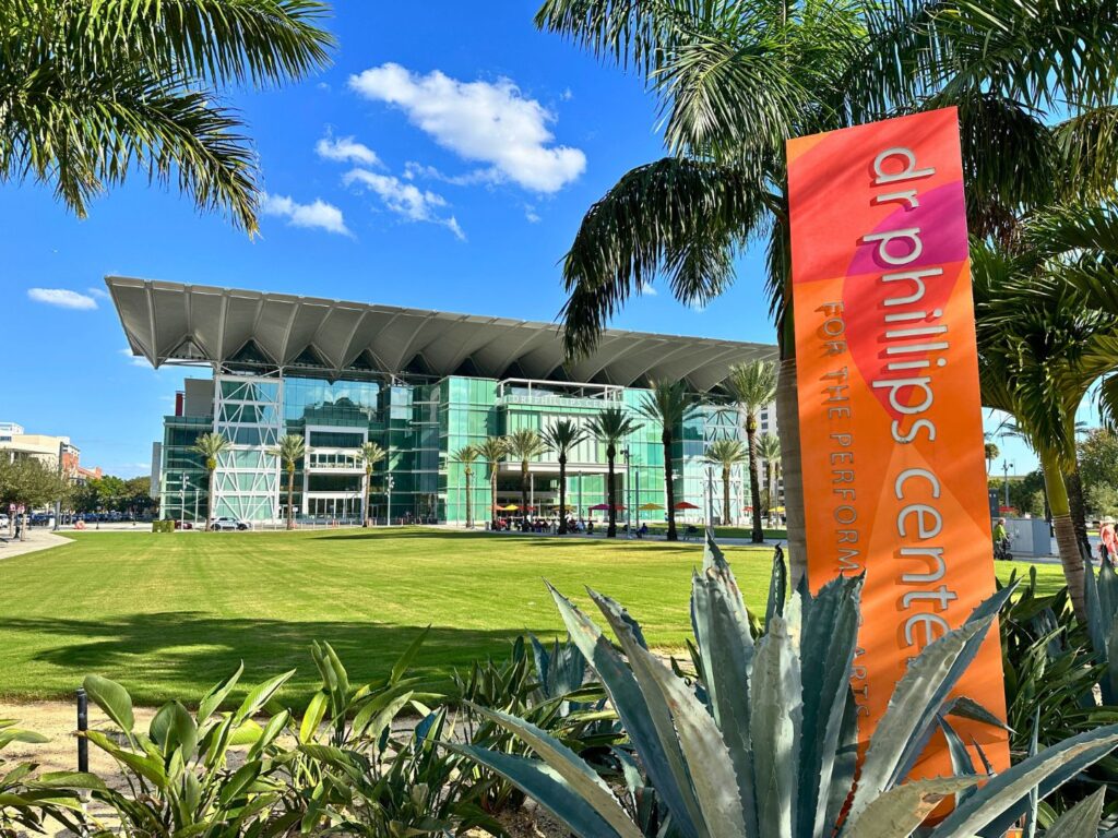 Outside the Dr. Phillips Center for the Performing Arts with sign and landscaped plants