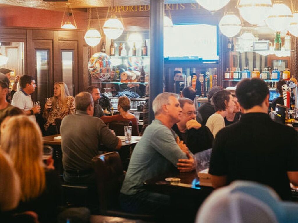 Image and multiple people sitting at the bar in The Castle Irish Pub