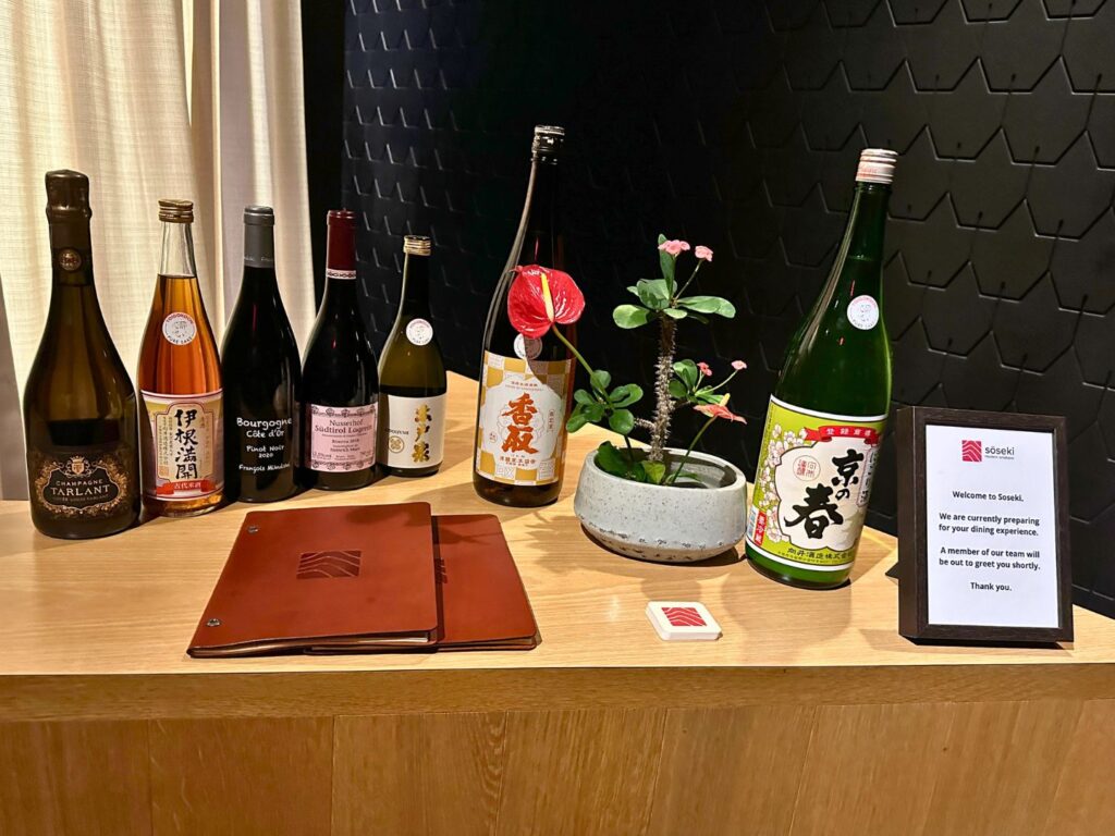 wine and sake bottles on the greeter stand at Lobby at Soseki Winter Park