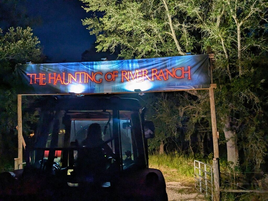 Haunting of River Ranch Hayride with themed banner overhead