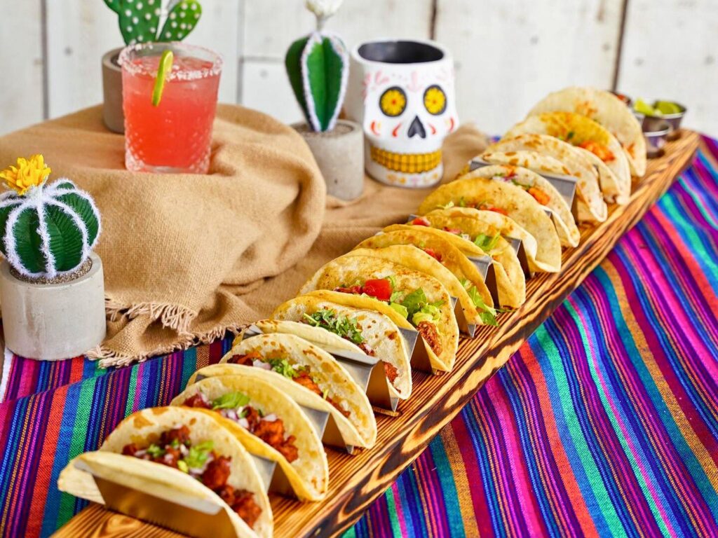 Image of a margarita and a 3 foot taco board with 12 tacos from Kavas Tacos 