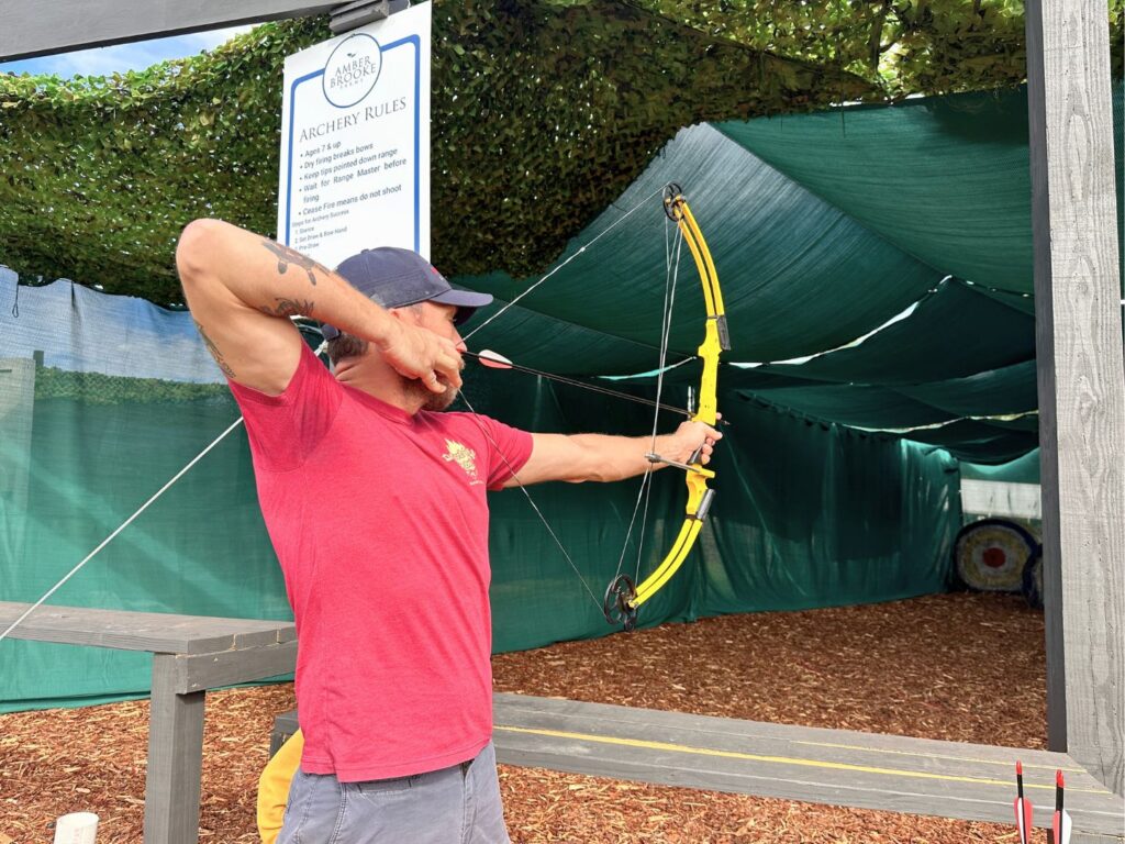 Man Aims Bow and Arrow at Archery at Amber Brooke Farms Eustis Near Orlando