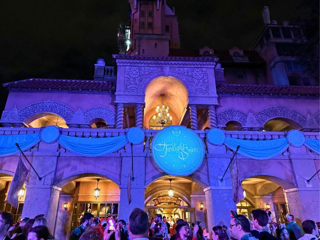 Twilight Soirée at The Tip-Top Club at Disney Jollywood Nights Courtyard with purple and blue lighting at night