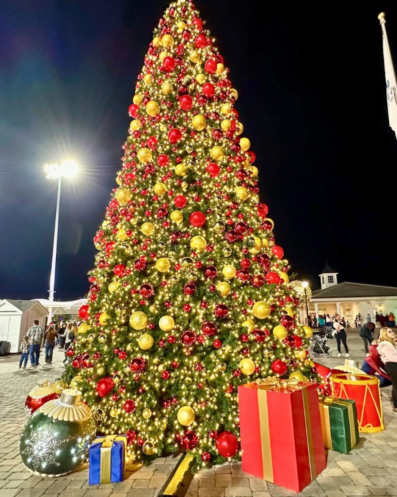 Image of large Christmas tree decorated in gold and red ornaments at Holiday Lights at Ocala's World Equestrian Center Winter Wonderland