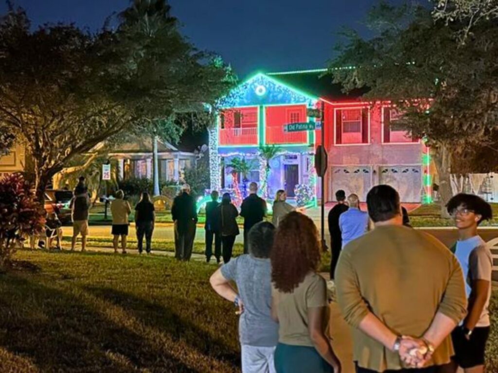 a small crowd watches Lake Nona Lights display on a home