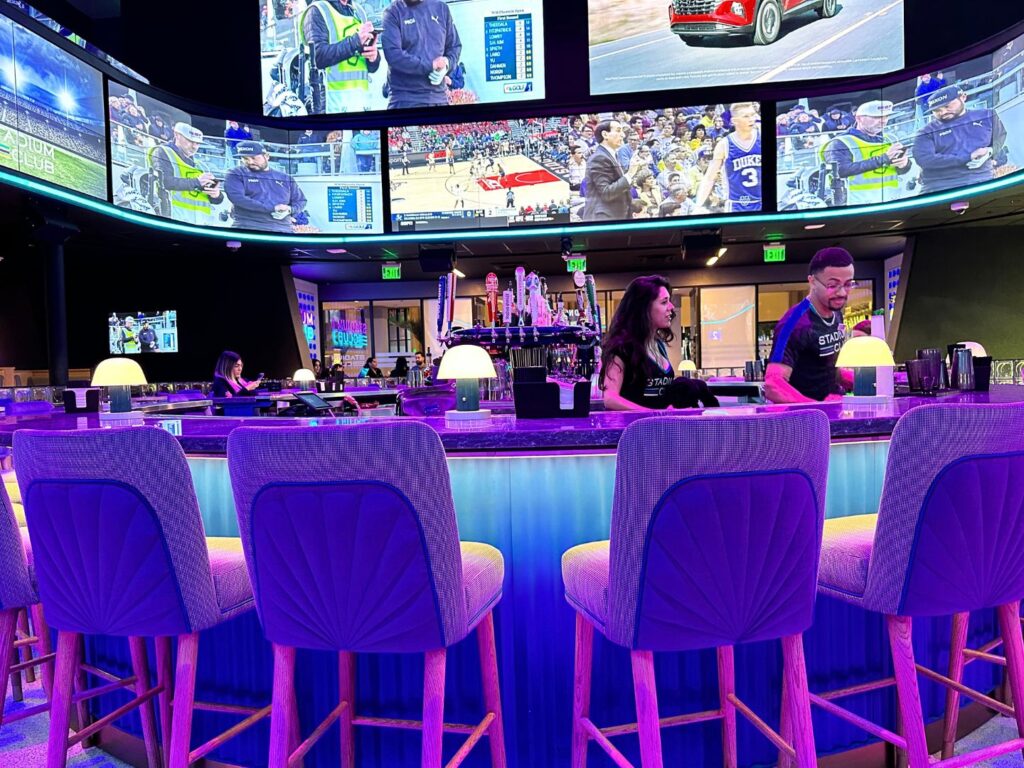 seats and bartenders at Bar with large Screens Stadium Club Caribe Royale 