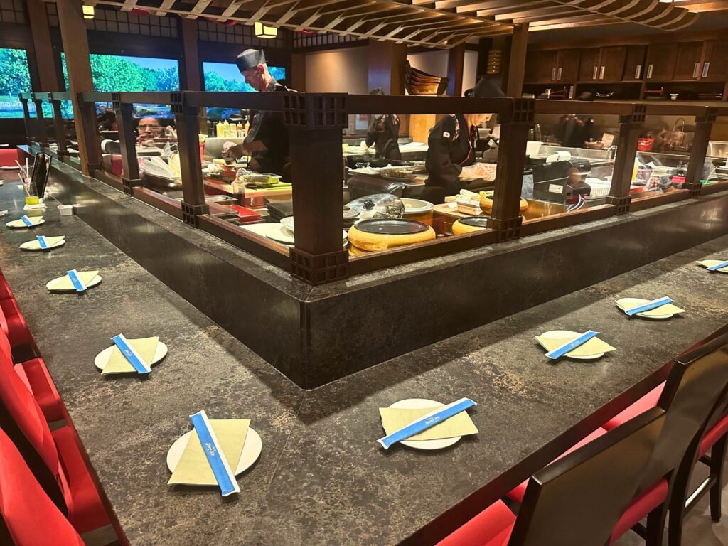 Image of the sushi bar and two employees at EPCOT’s Shiki-Sai