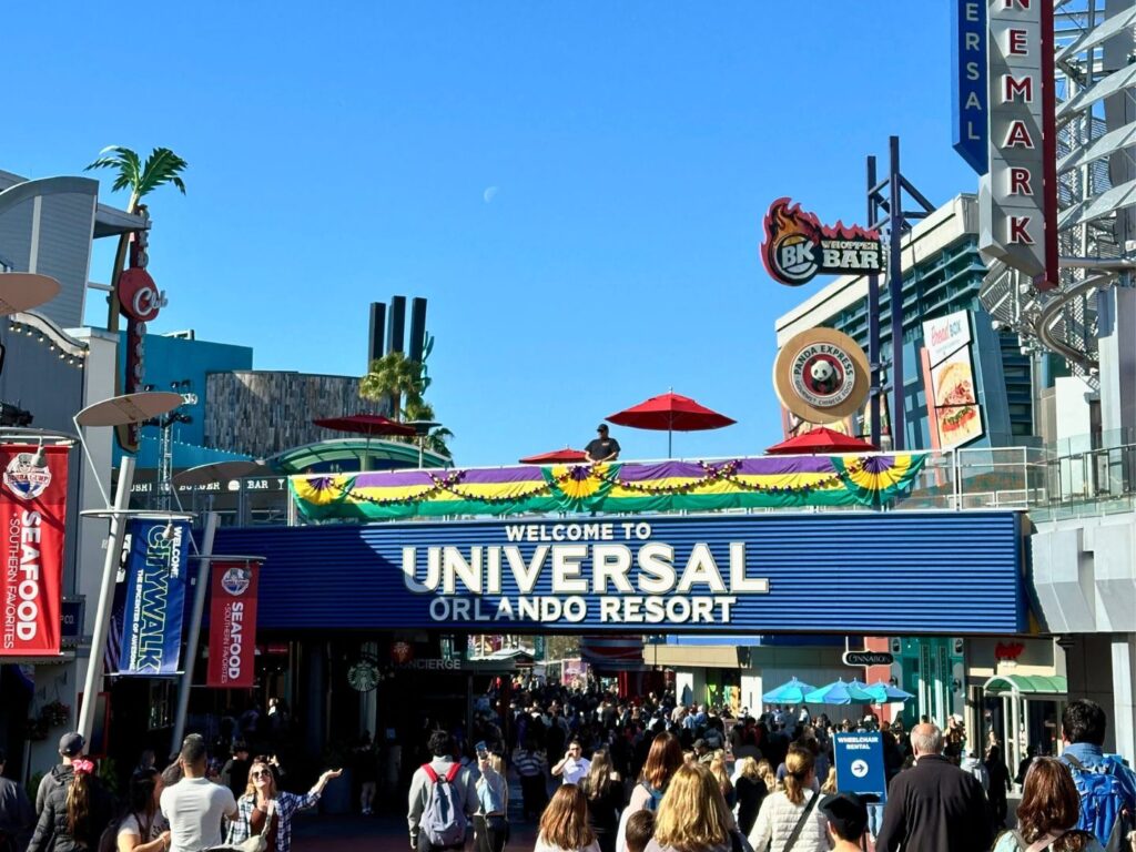 Universal CityWalk Mardi Gras Decorations hang above a walkway as crowds pass through