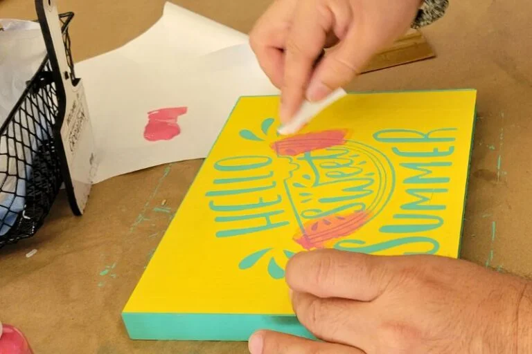 a man works on a summer themed painted sign at once upon a creation art studio in clermont florida