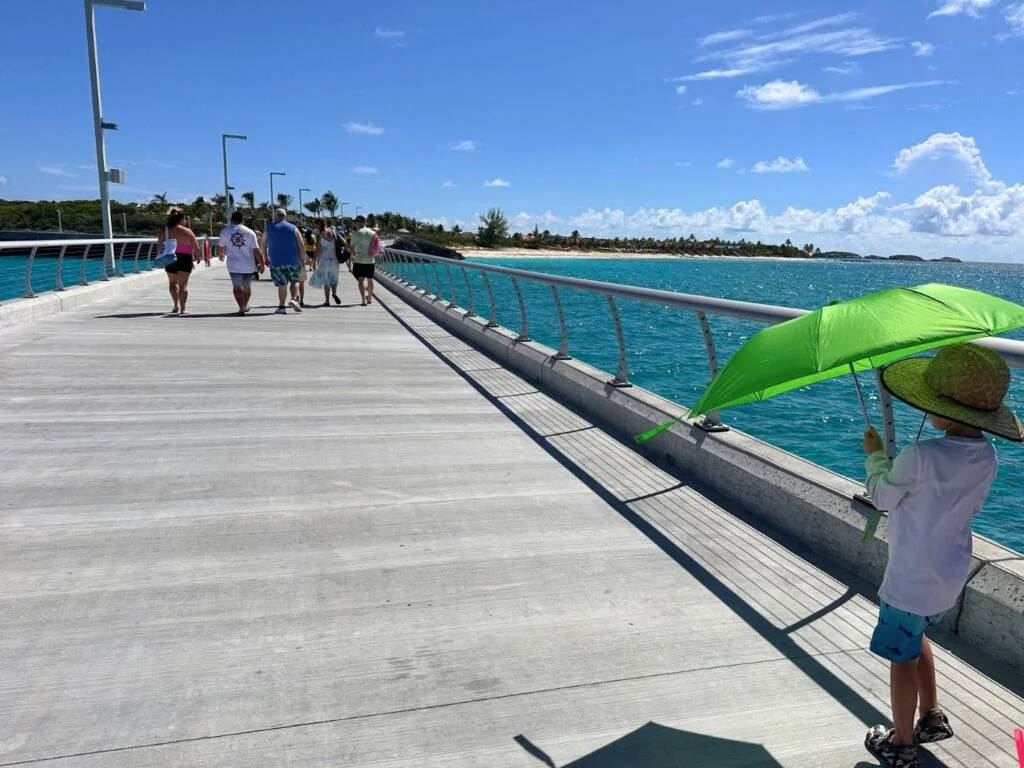 Young boy with umbrella on Lookout Cay pier long walkway