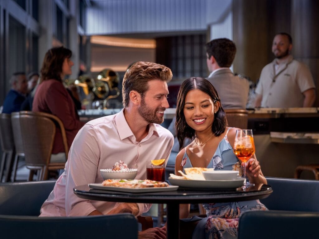 a couple enjoys cocktails and some food at Apéro bar at conrad orlando