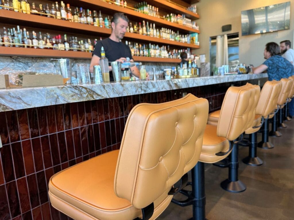 Packwoods Bar at Maitland Social - comfortable bar seating with two male patrons and a male bartender