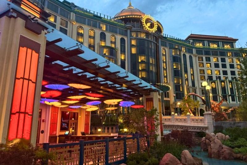 Blue Dragon outdoor dining Epic Universe with Helios Grand Hotel in background - image by Jodi Caballero
