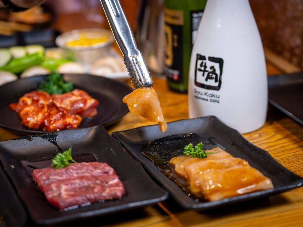 lifting chicken to put grill with sake at Gyu-Kaku Orlando date night