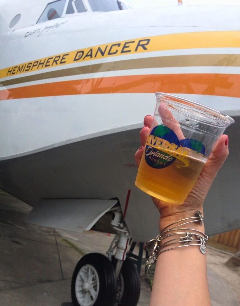 holding a drink in front of the Hemisphere Dancer at Orlando Margaritaville - image from Dani Meyering