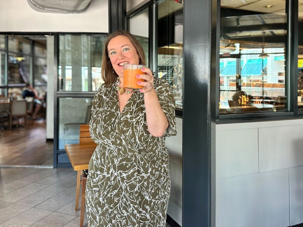Dani Meyering holds up Sunshine Boost Juice at Bigfire Brunch Universal Orlando - image from Dani Meyering