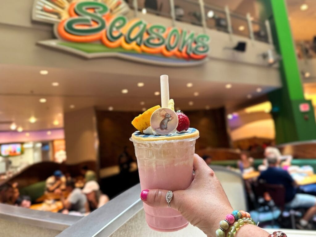 EPCOT Food and Wine Festival 2025 Strawberry Cheesecake Remy Milk Shake Sunshine Seasons held by photographer - image by Dani Meyering