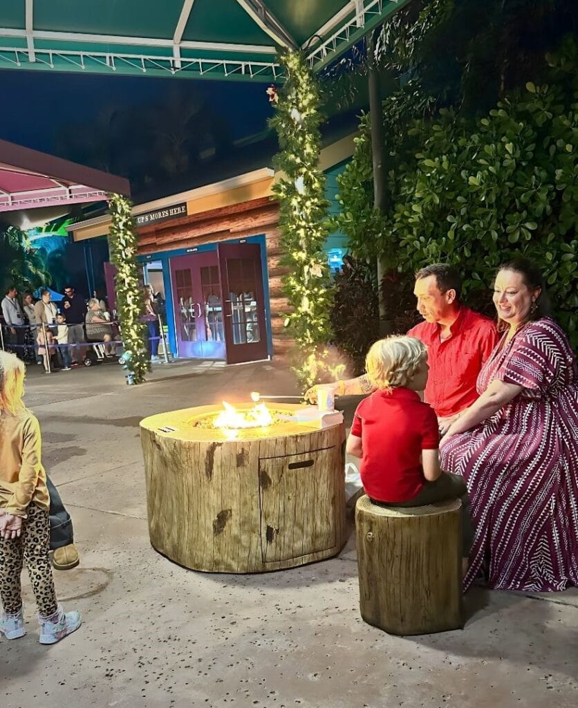 Husband and wife with young son enjoy s'mores area of ILLUMINATE Aquatica Orlando - image by Dani Meyering