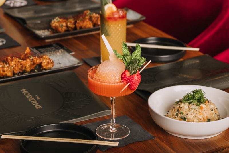 a table with menu and cocktail at The Moderne 