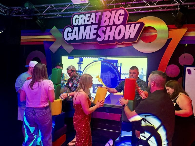 The two groups are competing against each other and stacking oversized, colorful foam blocks at Great Big Game Show