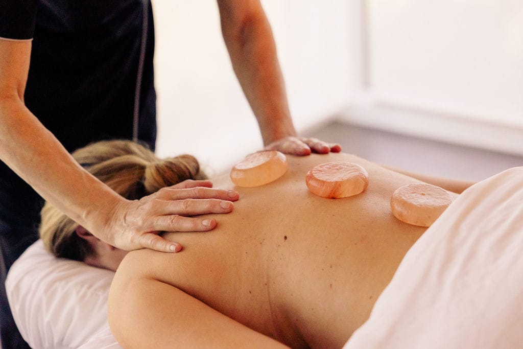 A woman getting a massage with stone therapy from JW Marriott Orlando Bonnet Creek Resort & Spa Wellness Retreat