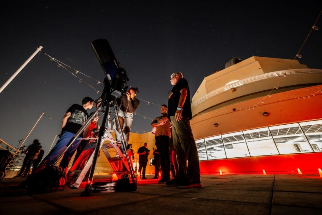 OSC After Dark attendee looking through telescope